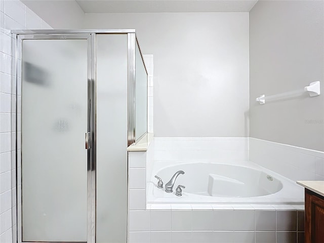 full bathroom with a bath, a stall shower, and vanity