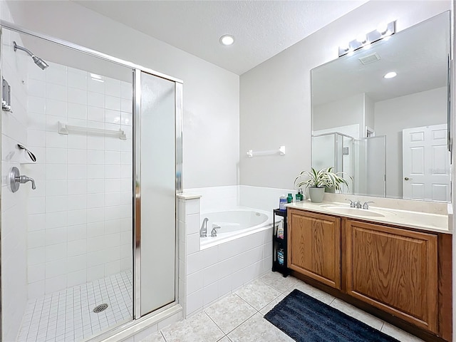 bathroom with visible vents, a garden tub, a stall shower, tile patterned flooring, and vanity