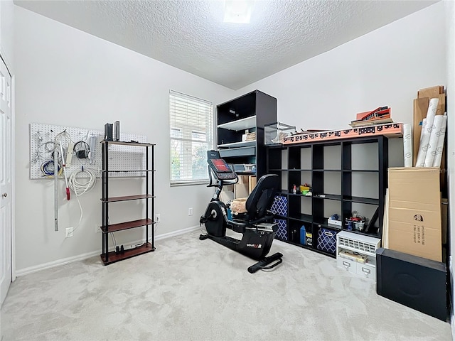 workout room with a textured ceiling, baseboards, and carpet floors