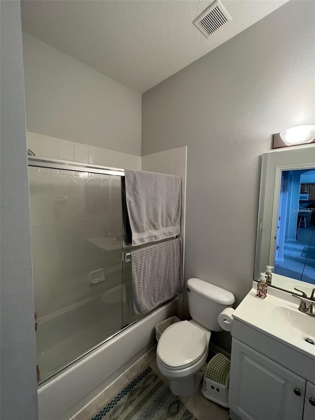 full bath featuring enclosed tub / shower combo, toilet, vanity, and visible vents