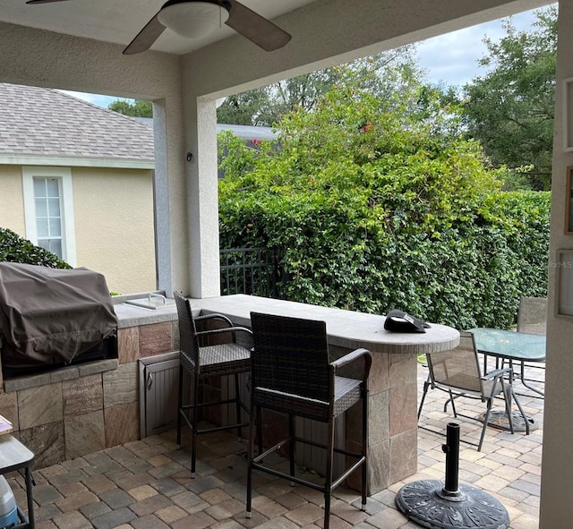 view of patio / terrace with outdoor dry bar, grilling area, and a ceiling fan