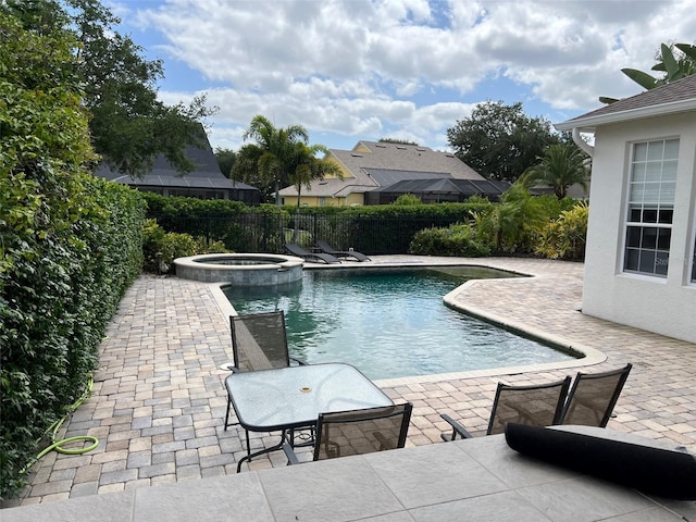 view of pool featuring a patio, fence, and a pool with connected hot tub