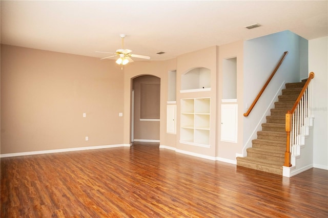 11474 Claymont Cir, Windermere, FL 34786 - unfurnished room with wood finished floors, built in shelves, arched walkways, a ceiling fan, and stairs
