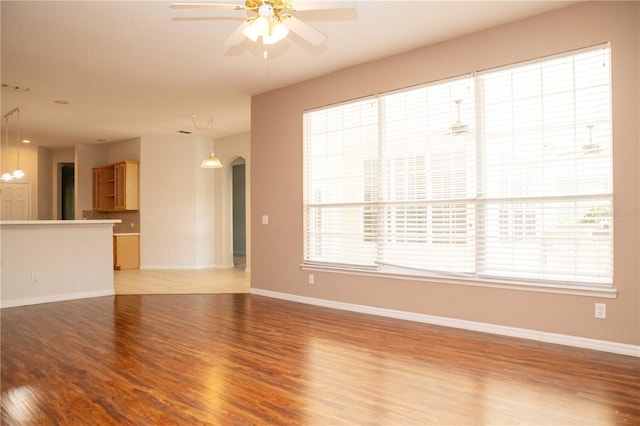 11474 Claymont Cir, Windermere, FL 34786 - unfurnished living room featuring arched walkways, light wood-style floors, and ceiling fan