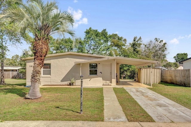 view of front of house featuring concrete driveway, a carport, a front yard, and fence