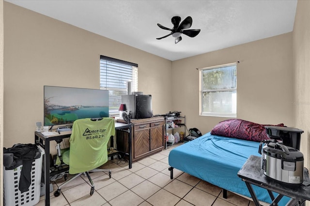 bedroom featuring a ceiling fan, multiple windows, and light tile patterned floors