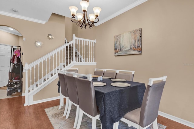 dining space featuring crown molding, stairs, baseboards, and wood finished floors