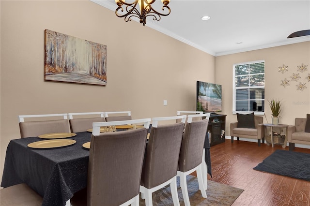 dining space with baseboards, wood finished floors, an inviting chandelier, crown molding, and recessed lighting