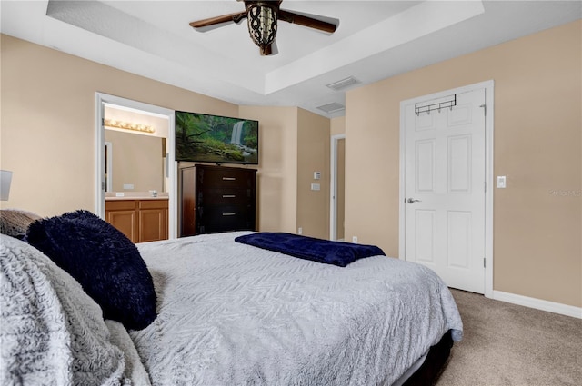 bedroom featuring a tray ceiling, visible vents, a ceiling fan, carpet flooring, and baseboards