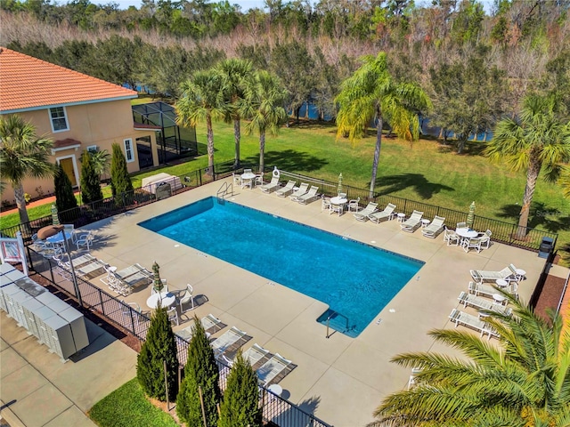 pool featuring a yard, a patio area, and fence