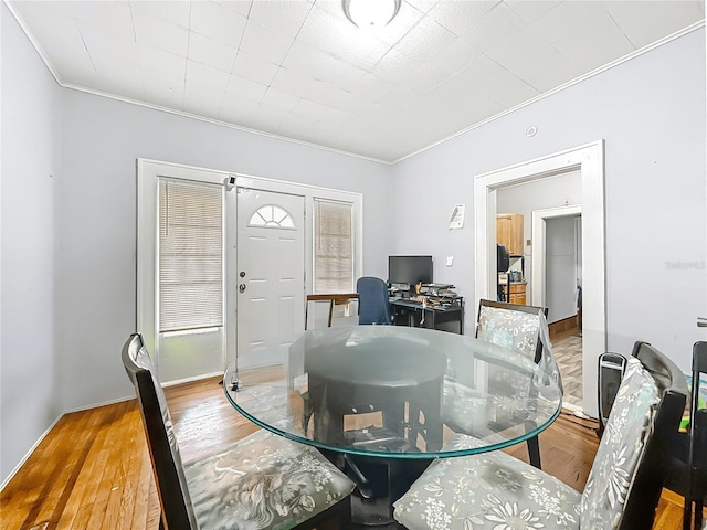 dining space featuring ornamental molding and wood finished floors