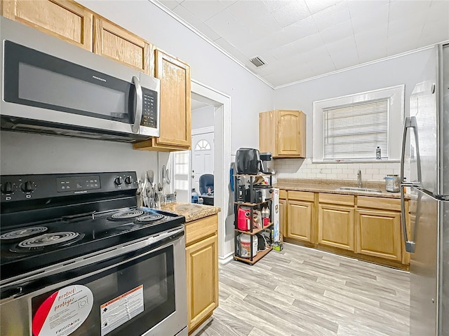 kitchen featuring tasteful backsplash, light wood-type flooring, visible vents, stainless steel appliances, and a sink