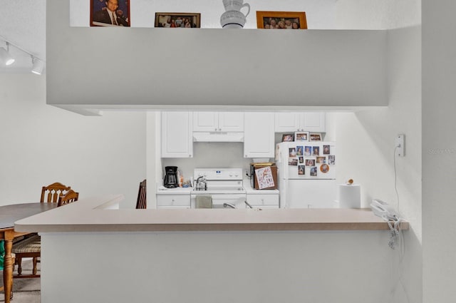 kitchen featuring under cabinet range hood, a peninsula, white appliances, white cabinetry, and light countertops