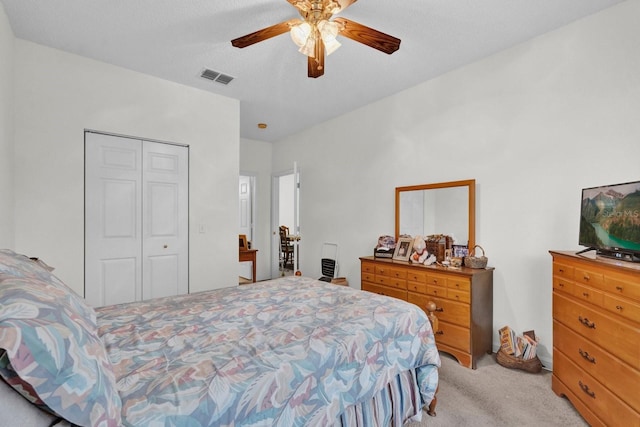 bedroom with light carpet, ceiling fan, a closet, and visible vents