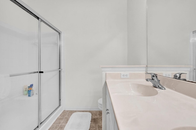 bathroom with a stall shower, baseboards, toilet, tile patterned floors, and vanity