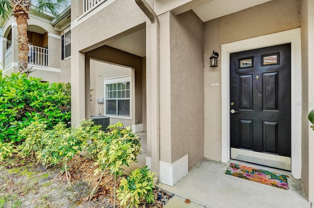 doorway to property featuring stucco siding