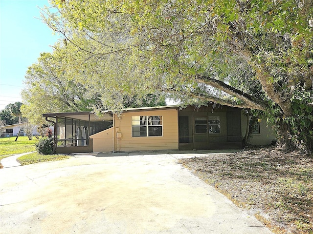 view of front of home featuring driveway and a sunroom