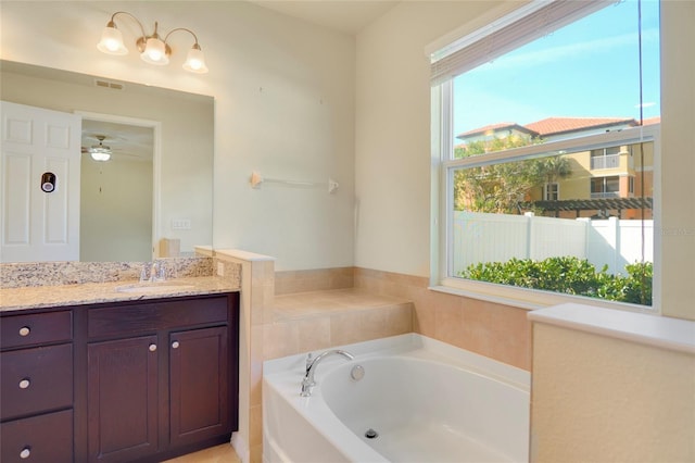 bathroom featuring visible vents, a garden tub, and vanity