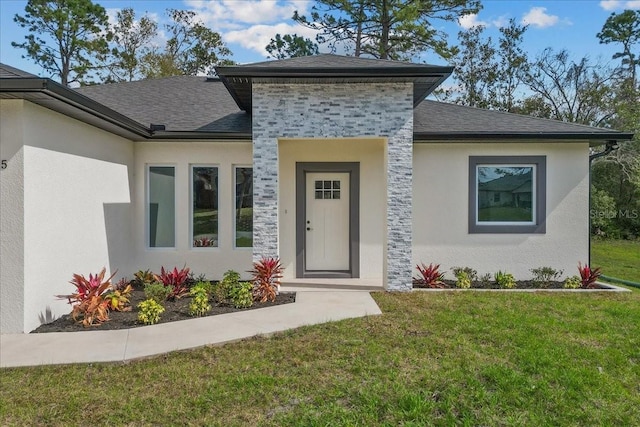 exterior space with stone siding, roof with shingles, a yard, and stucco siding