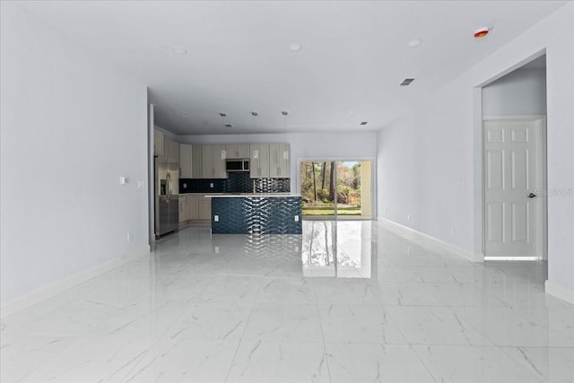 unfurnished living room featuring marble finish floor and baseboards