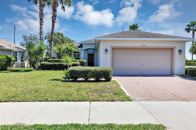 ranch-style home featuring stucco siding, a front yard, decorative driveway, and a garage