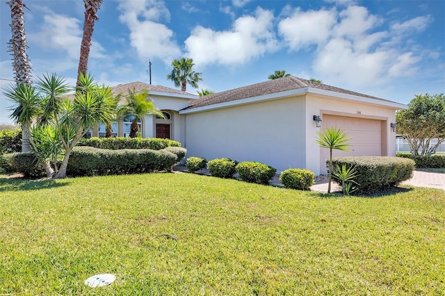 view of front of house with stucco siding, driveway, a front yard, and a garage