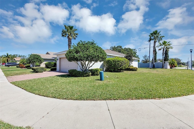 view of front of home with stucco siding, driveway, a front yard, and a garage