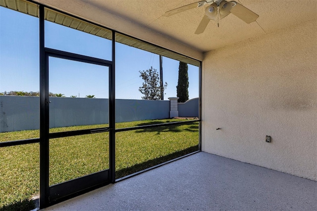 unfurnished sunroom featuring ceiling fan