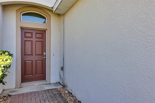 property entrance with stucco siding