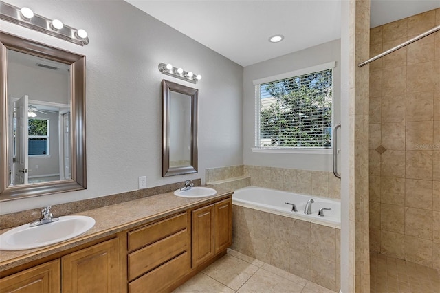 bathroom with tile patterned floors, tiled shower, a garden tub, and a sink