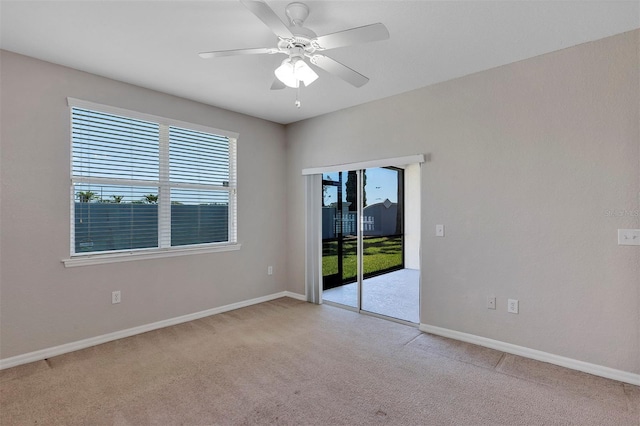 unfurnished room featuring light colored carpet, baseboards, and ceiling fan