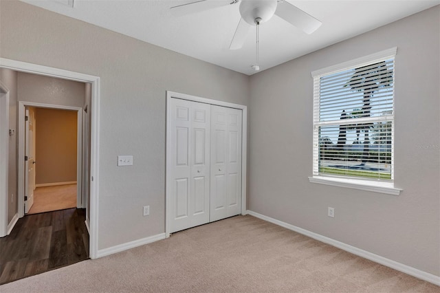 unfurnished bedroom featuring a closet, baseboards, a ceiling fan, and carpet flooring