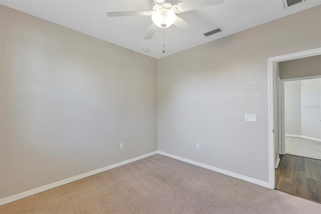 carpeted empty room featuring visible vents, baseboards, and a ceiling fan