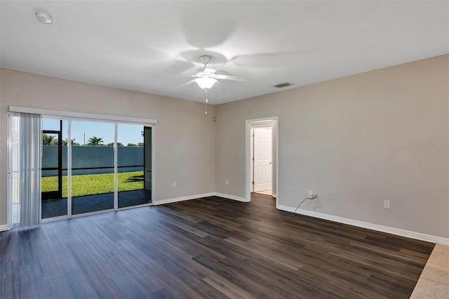 empty room with visible vents, baseboards, dark wood-type flooring, and ceiling fan