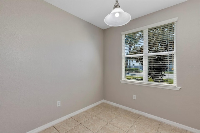 unfurnished room with light tile patterned floors and baseboards