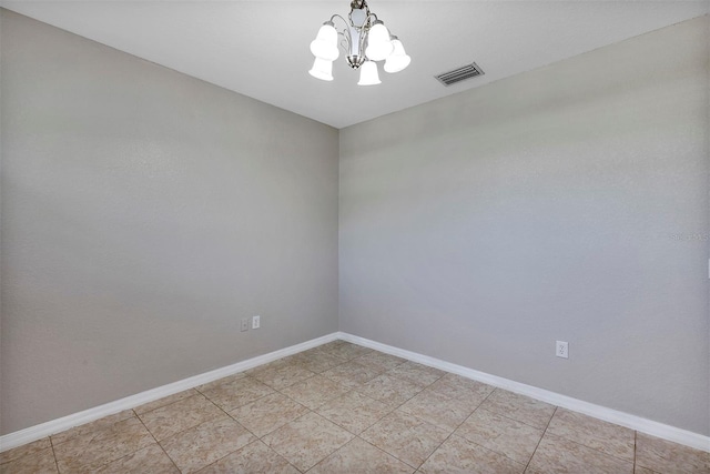 empty room featuring a notable chandelier, baseboards, and visible vents