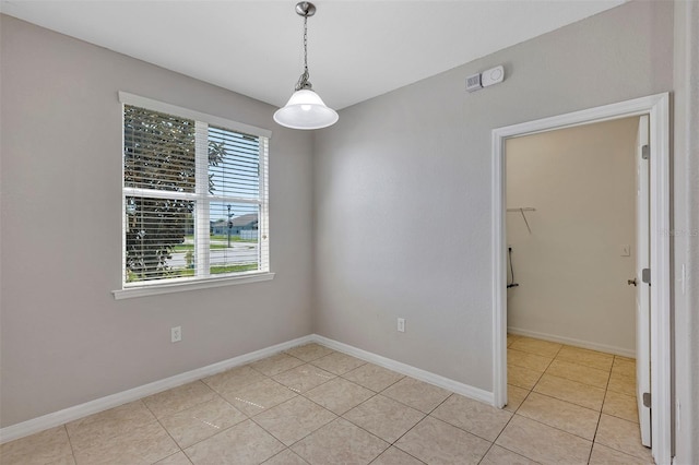 unfurnished room with light tile patterned floors and baseboards