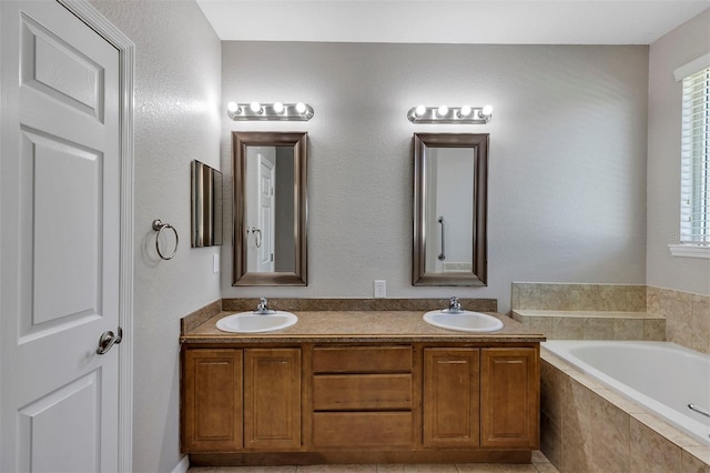 bathroom featuring a garden tub, plenty of natural light, and a sink