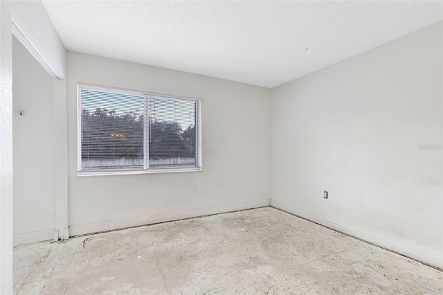 empty room featuring baseboards and a textured ceiling