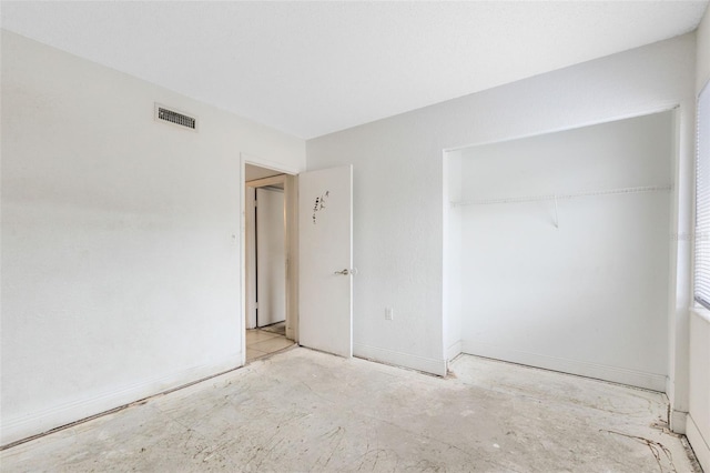 unfurnished bedroom with baseboards, visible vents, and a closet