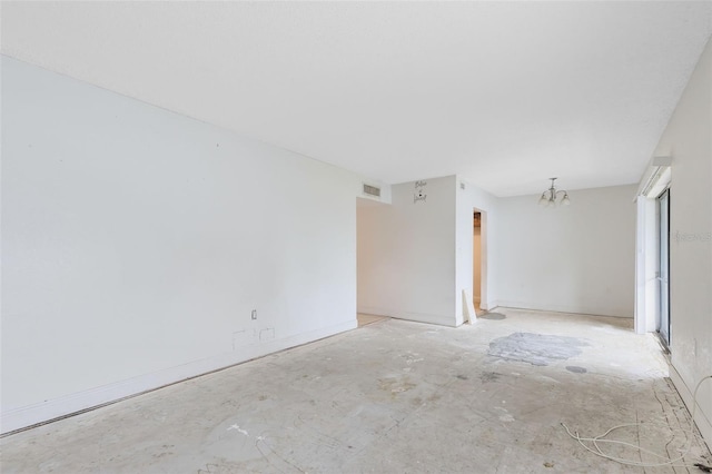 spare room with visible vents and a notable chandelier