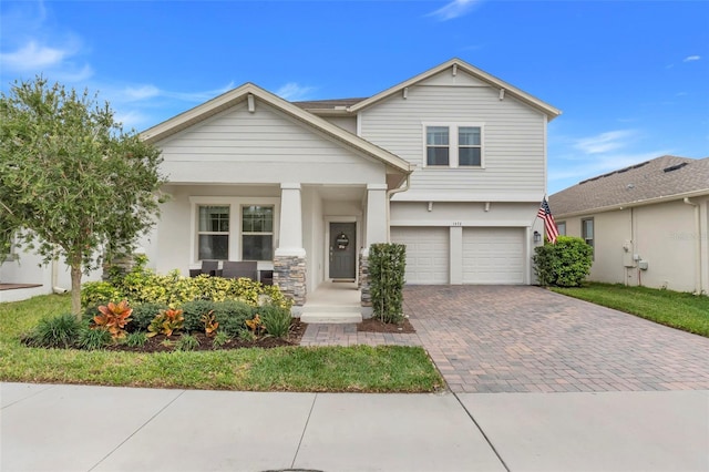 craftsman-style house featuring decorative driveway and an attached garage