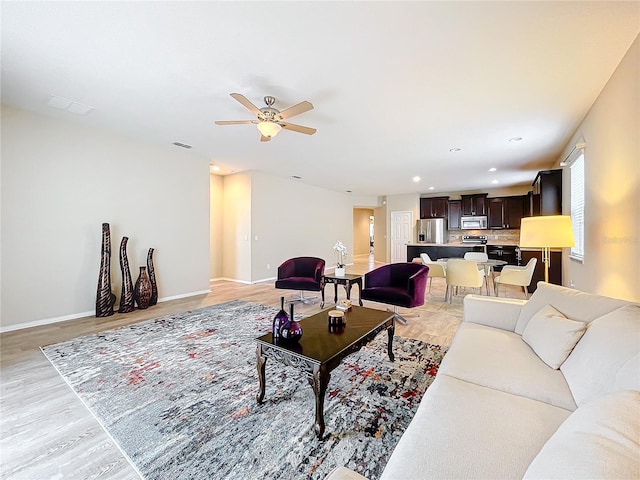 living room with recessed lighting, a ceiling fan, baseboards, visible vents, and light wood-style floors