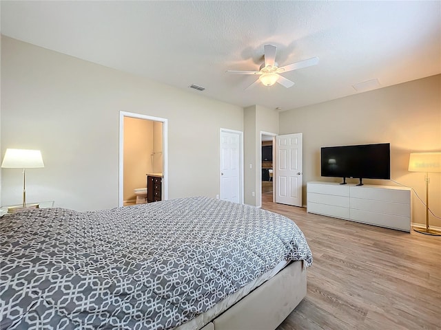 bedroom featuring visible vents, a ceiling fan, connected bathroom, a textured ceiling, and wood finished floors