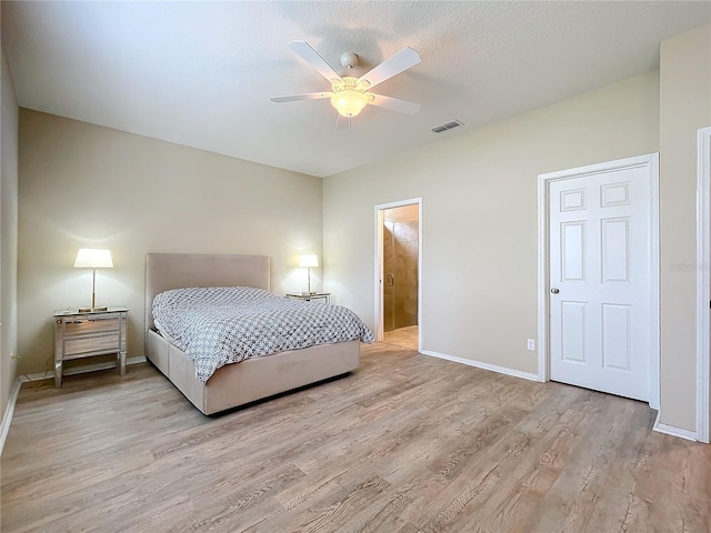 bedroom with ceiling fan, connected bathroom, light wood-style flooring, visible vents, and baseboards