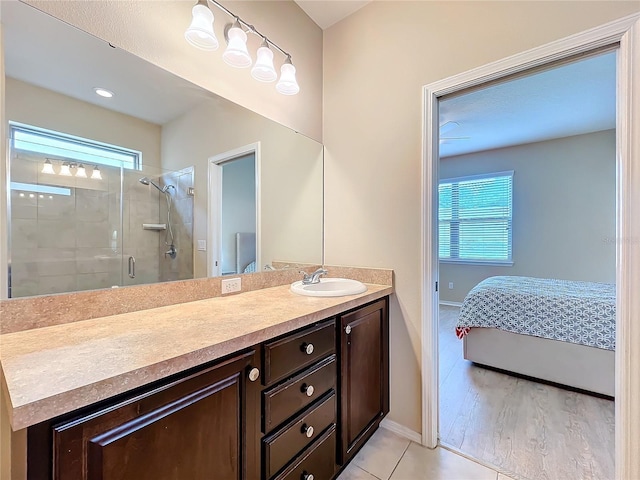 bathroom featuring baseboards, ensuite bath, vanity, and a shower stall