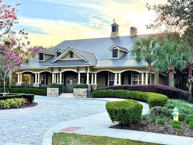 view of front of property featuring a standing seam roof, metal roof, and a chimney