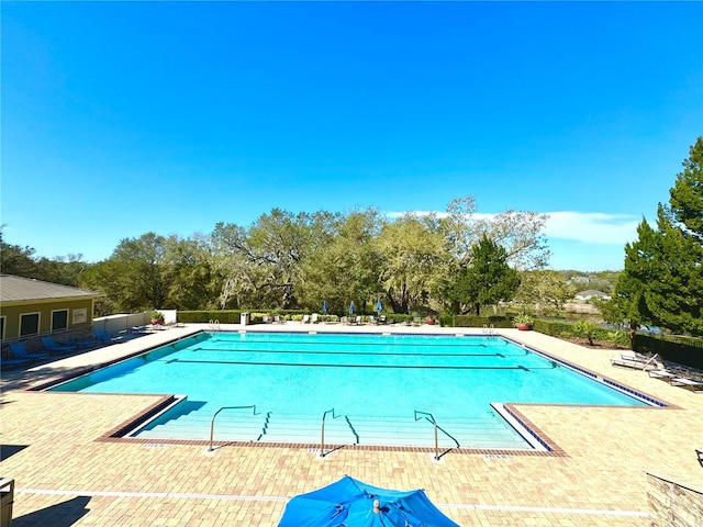 community pool featuring fence and a patio