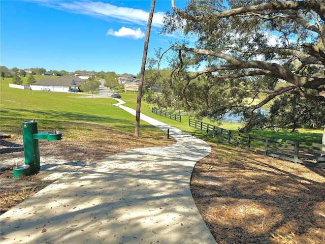 view of community with a lawn and fence