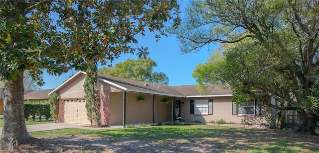 ranch-style home featuring a garage, a front yard, and concrete driveway